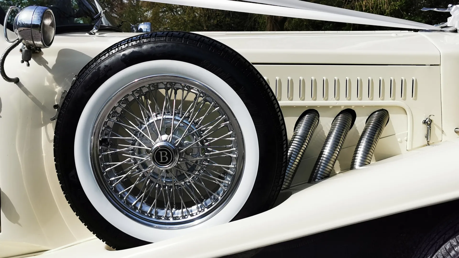 Front side view of the beauford showing the spare mounted wheel with white wall tires