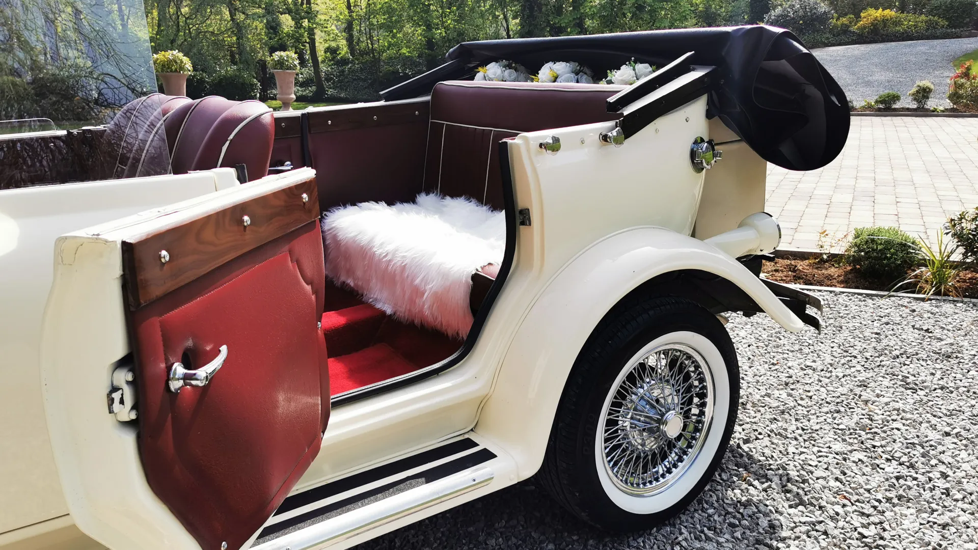 Side view of Convertible Vintage Beauford with roof down and rear passenger door open showing the burgundy leather interior