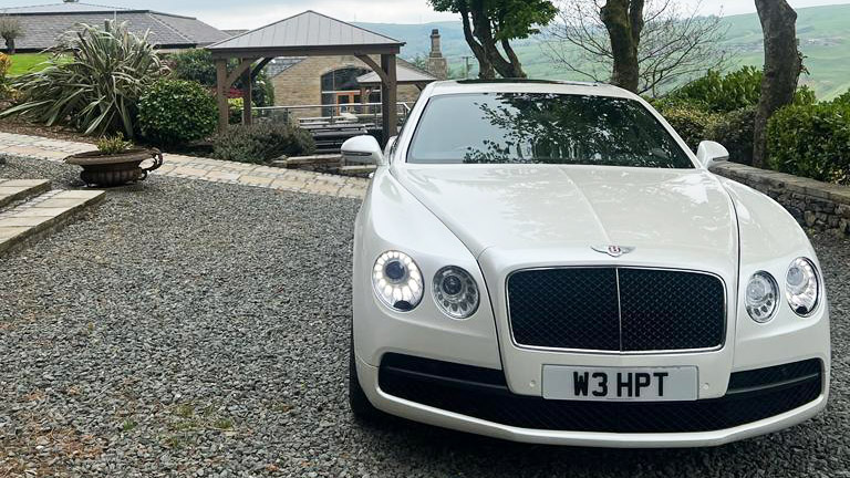Full front view of Modern White Bentley showing the Large Bentley Grill