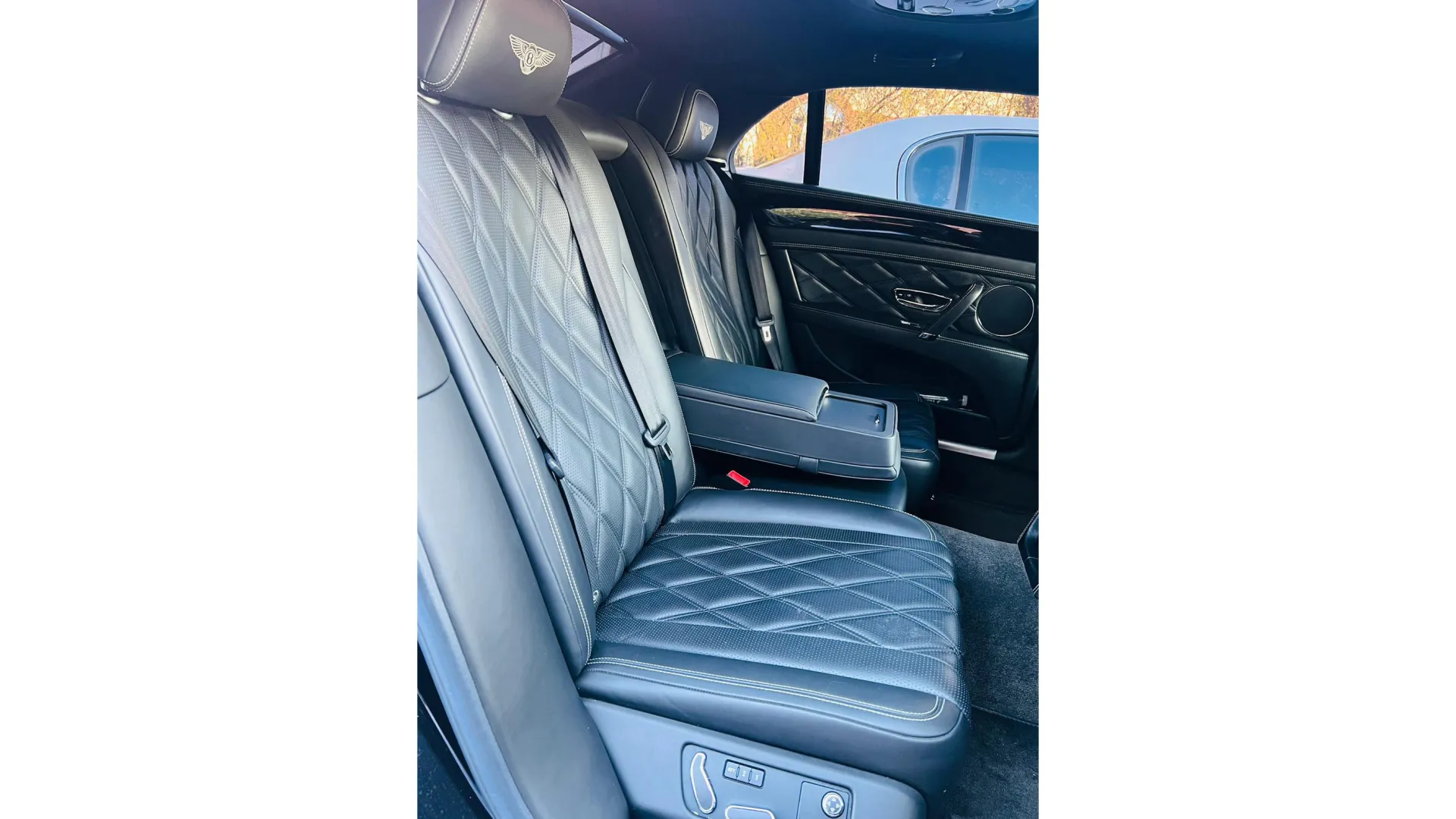 Rear passenger seating area in White Bentley Flying Spur with Black Leather interior