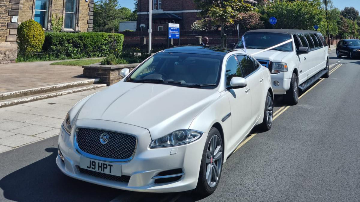 Front view of White Jaguar followed by a white Limousine