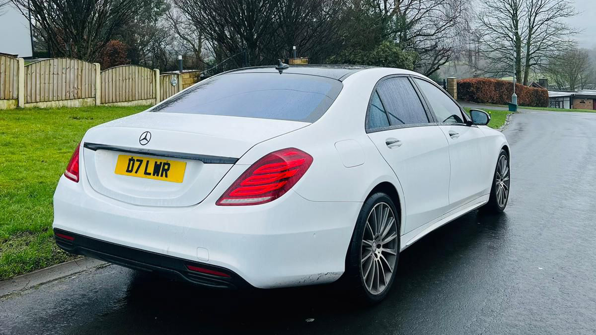 Rear Side View of White Mercedes parked on a road