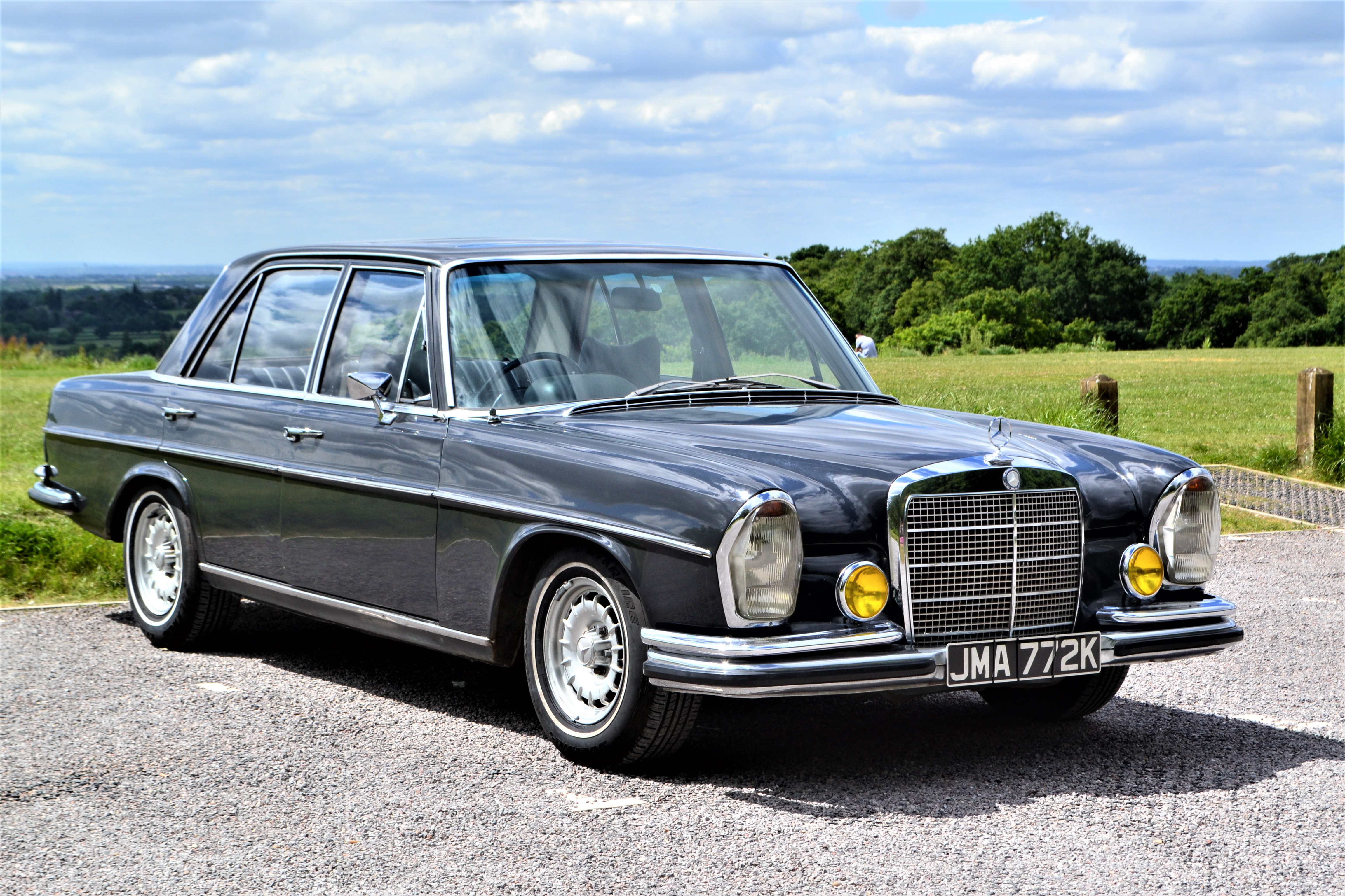 Front View of Grey Classic Mercedes fromt he early 70's with large headlights and chrome grill