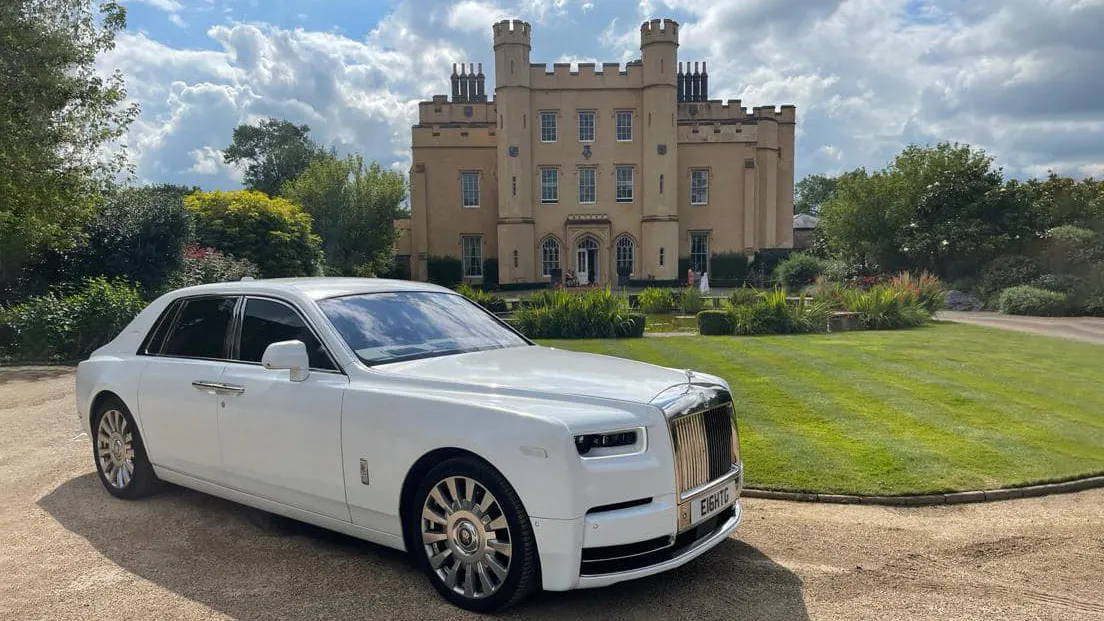 White Rolls-Royce Phantom 8 with its large chrome alloy wheels in attendance at a popular wedding venue in Kensington & Chelsea. Castle style building in the background.