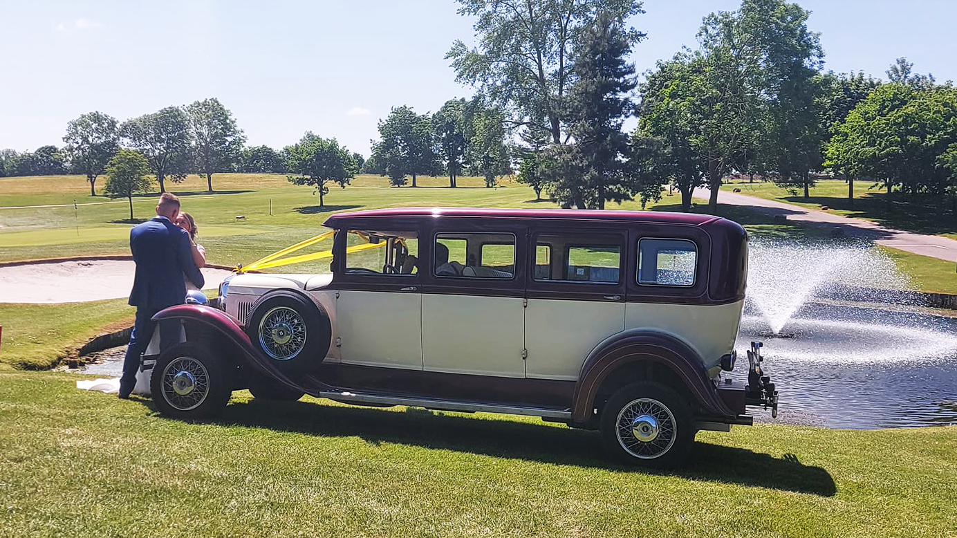 Bramwith Limousine in a Park with bride and groom kissing in front of the vehicle
