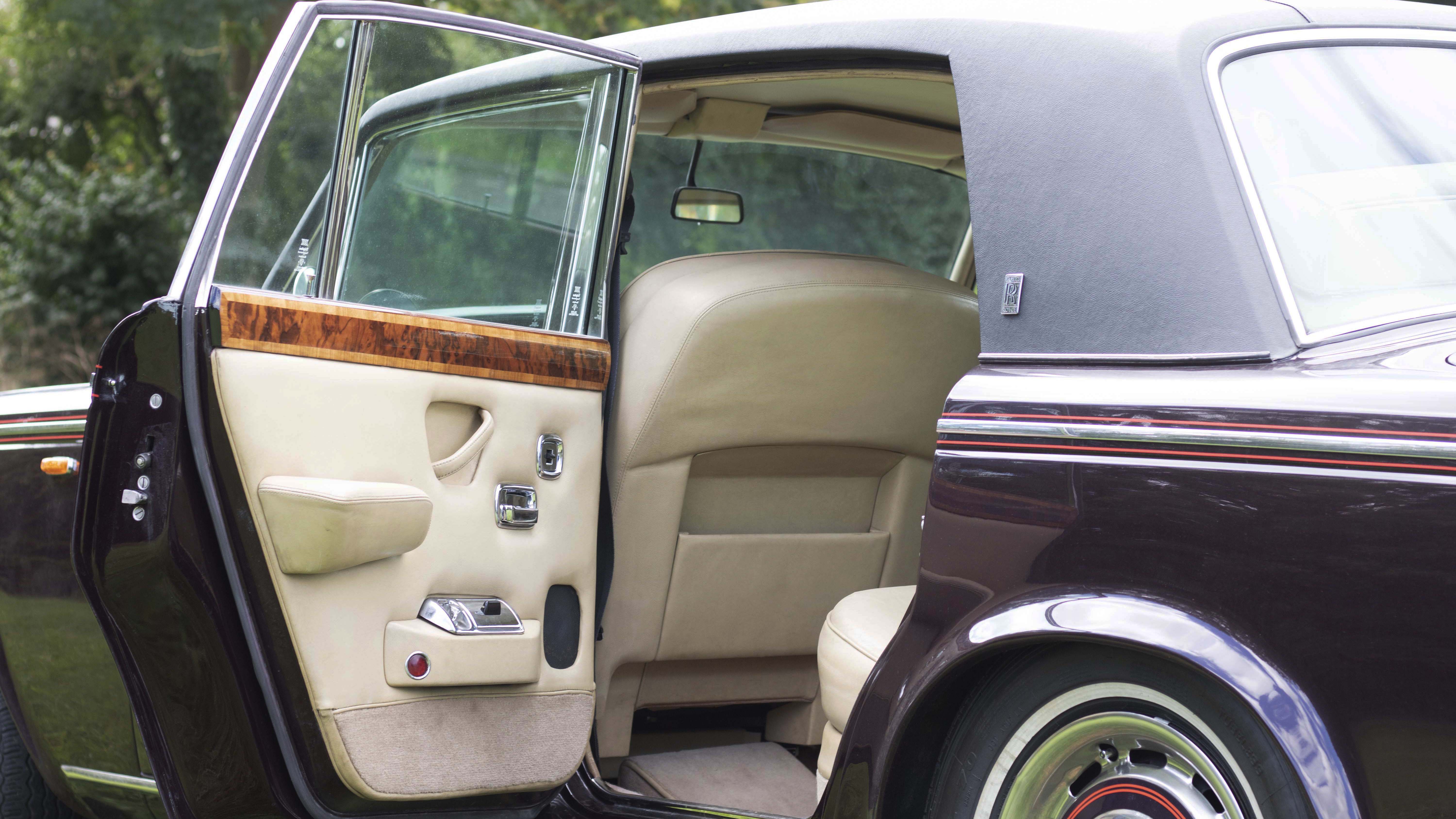 Rear left door open showing large amount of space in the rear. Cream door cards and seats