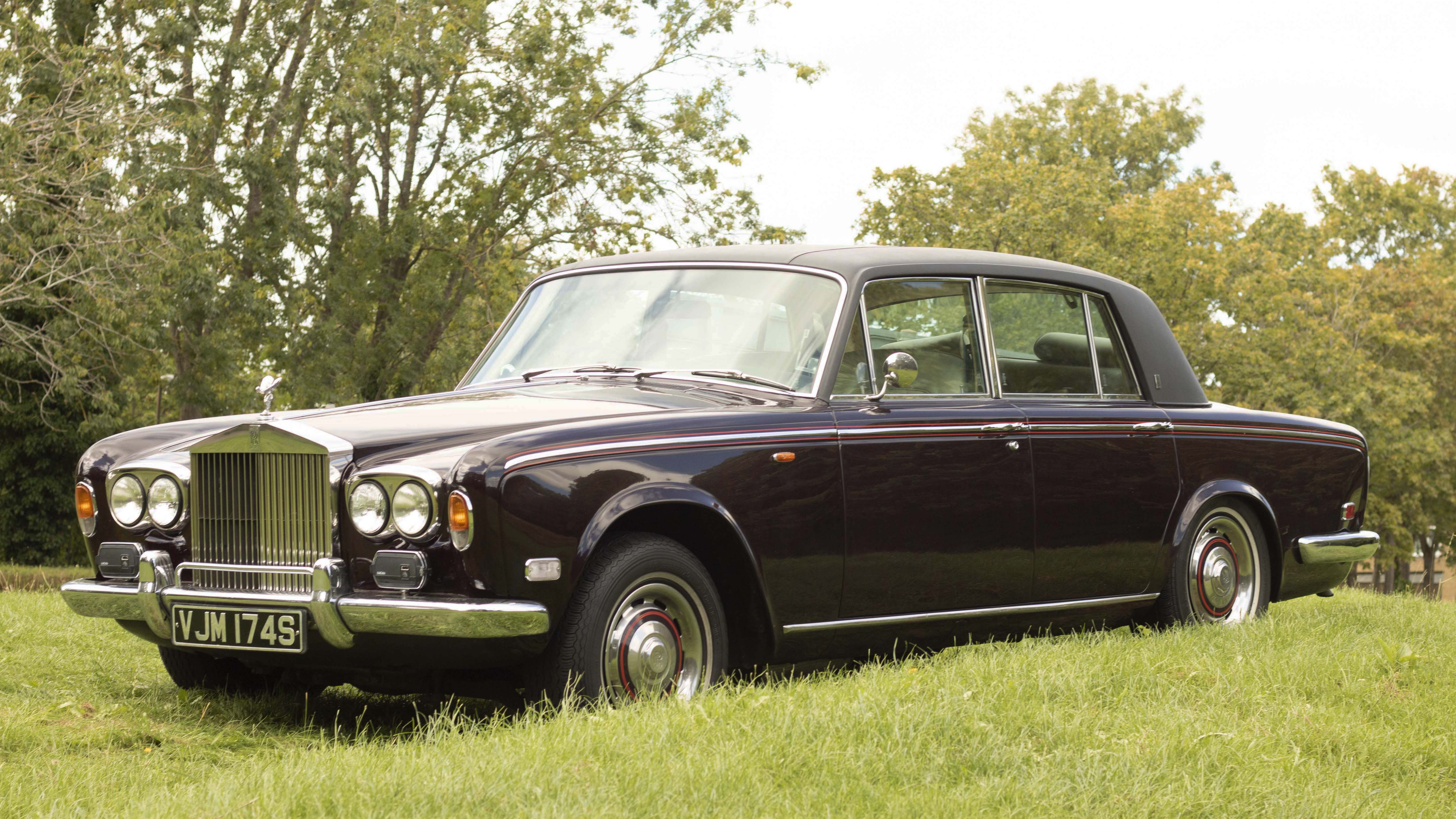 Side View of a classic Rolls-Royce silver Shadow Mk1 with Chrome Bumpers in a green field