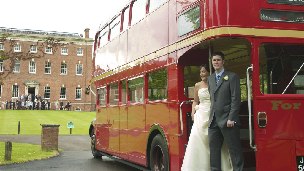 Bride and Groom standing on the rear open platform of a Red Routemaster Bus