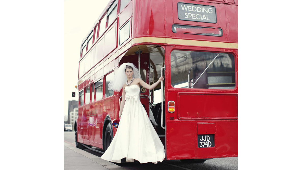 Bride stnadin on the rear open platform of Routemaster Bus