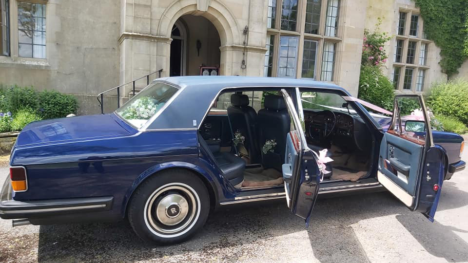 Side view of Blue rolls-royce silver spur showing blue leather interior and large legroom for rear passengers