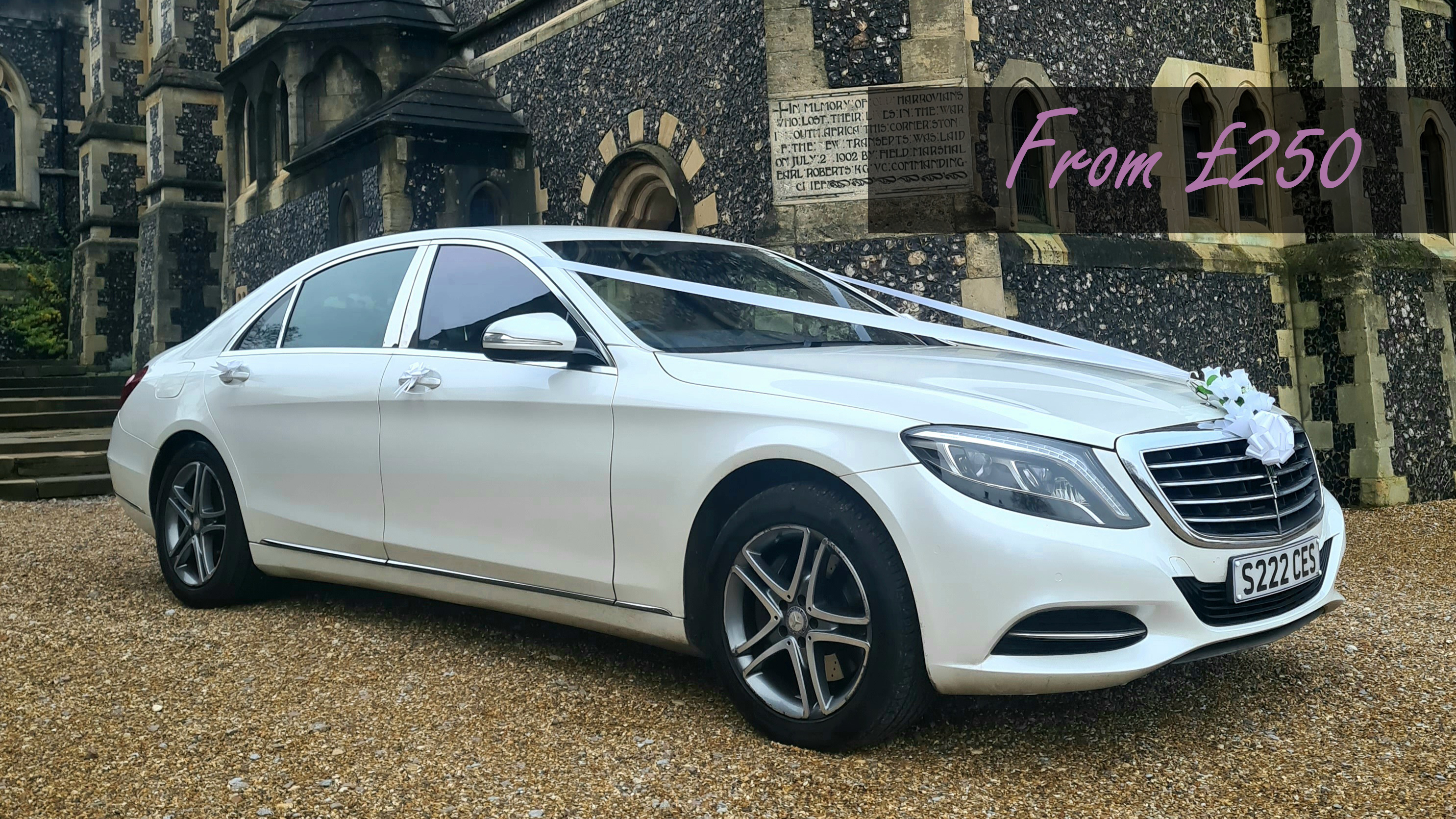 White Mercedes S-Class with white ribbons and bow in front of a wedding venue displaying an affordable from price of £250.