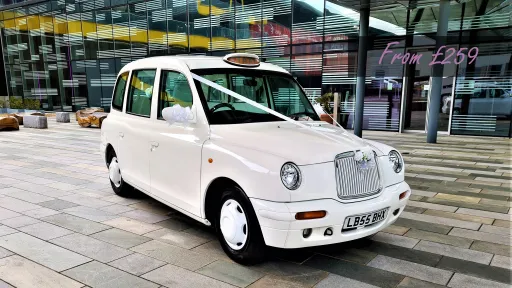 Modern White London Taxi Cab dressed with white ribbons across its front bonnet displaying a price of £259.