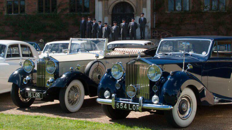 Selection of Classic and Vintage Cars in the front with Fully uniformed chauffeurs in the backgroun.