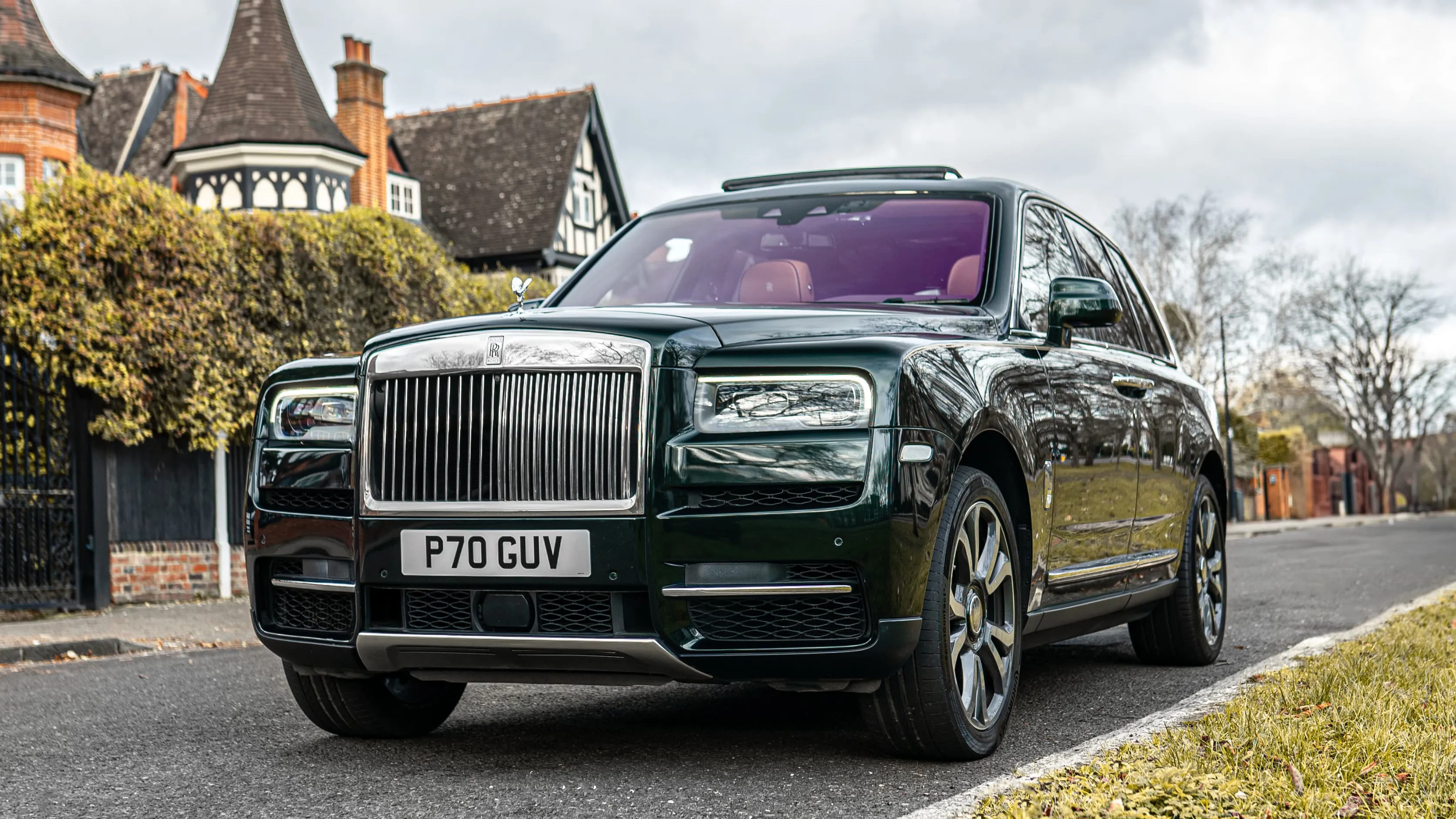 Dark green SUV Rolls-Royce Cullinan parked in street