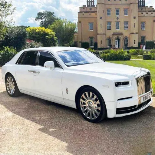 White Rolls-Royce Phantom 8 in front of a castle style wedding venue.