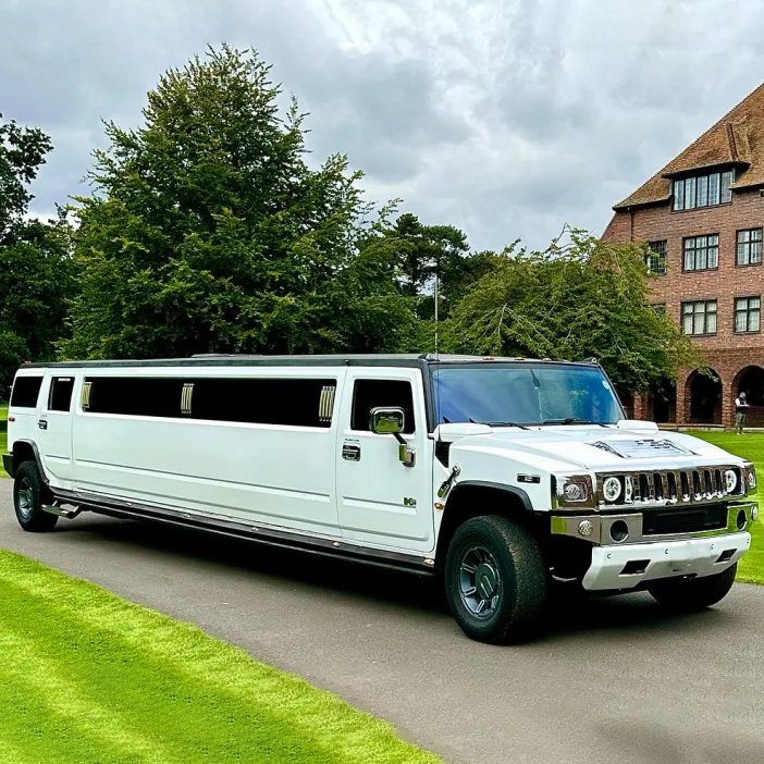 White 16-seater Hummer Stretched Limousine parked in front of a wedding venue.