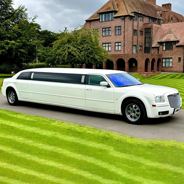White Stretched Limousine parked in front of a wedding venue.