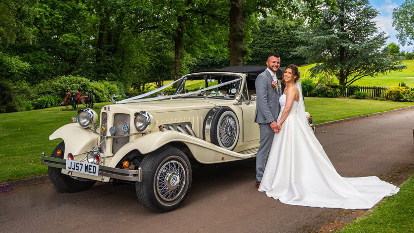Beauford Convertible in Ivory with Bride and Groom stnading next to the vehicle