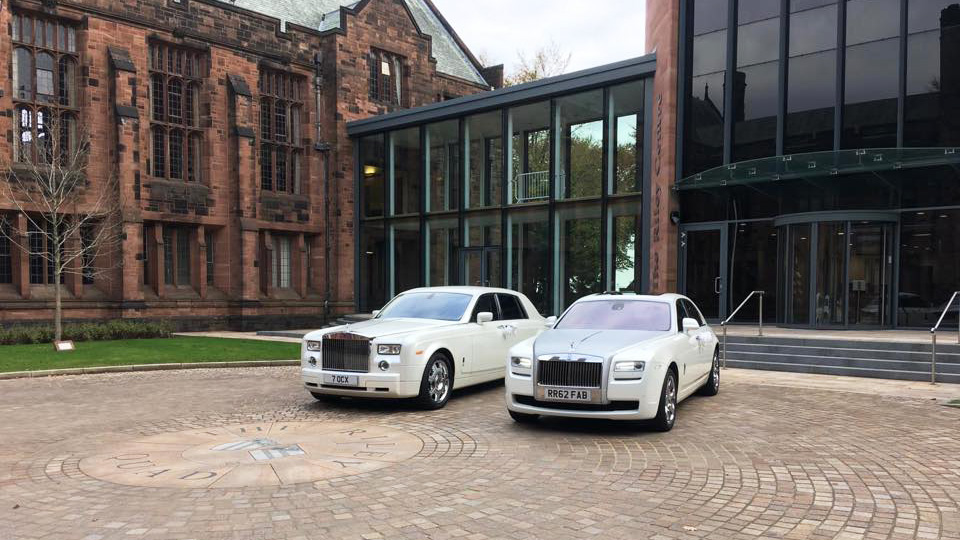 Two White Rolls-Royce Phantom and Ghost parked side-by-side in front of a wedding venue in Yorkshire.