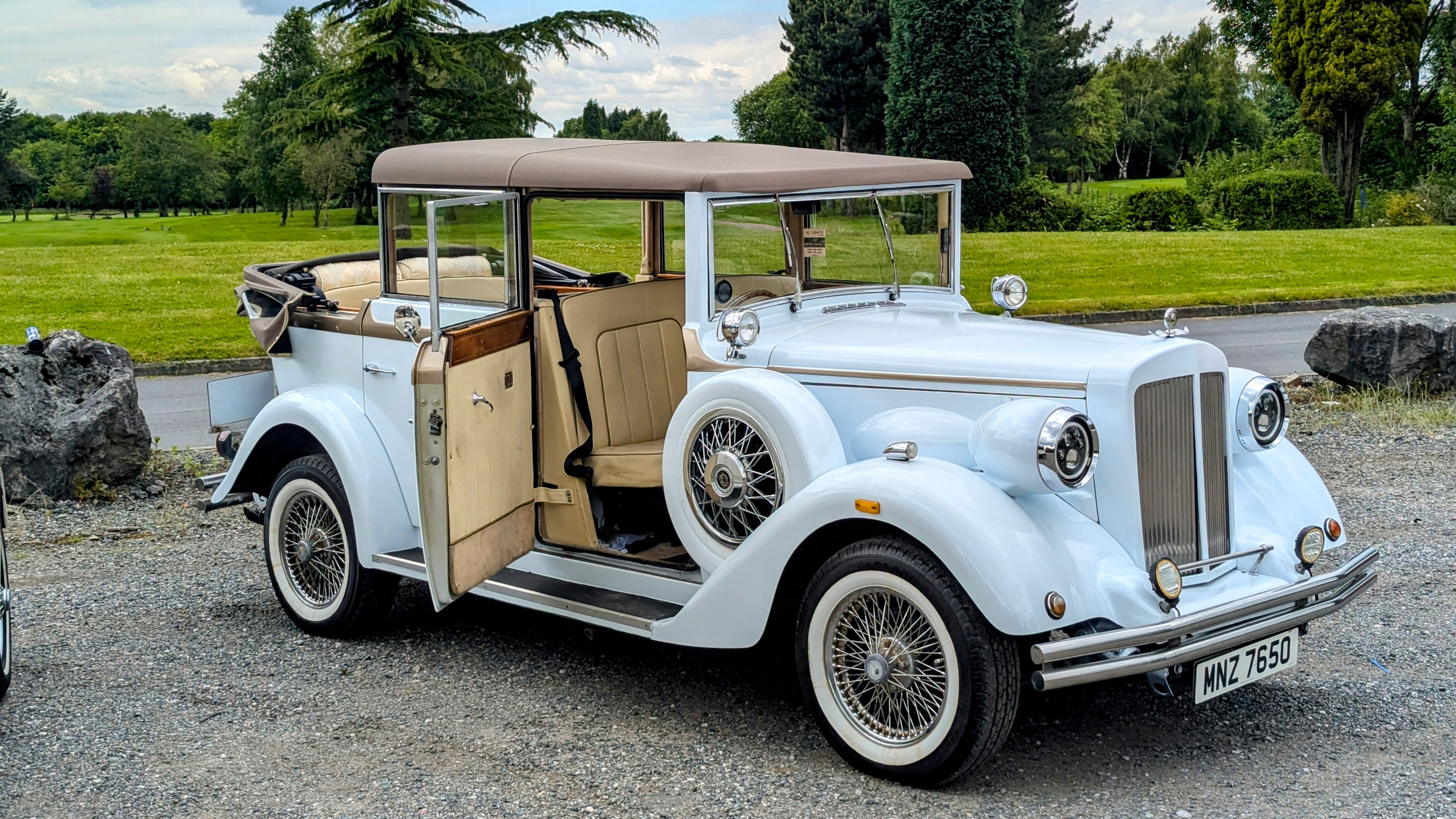White Beauford with roof soft top roof down and front driver's door open showing a Cream leather interior