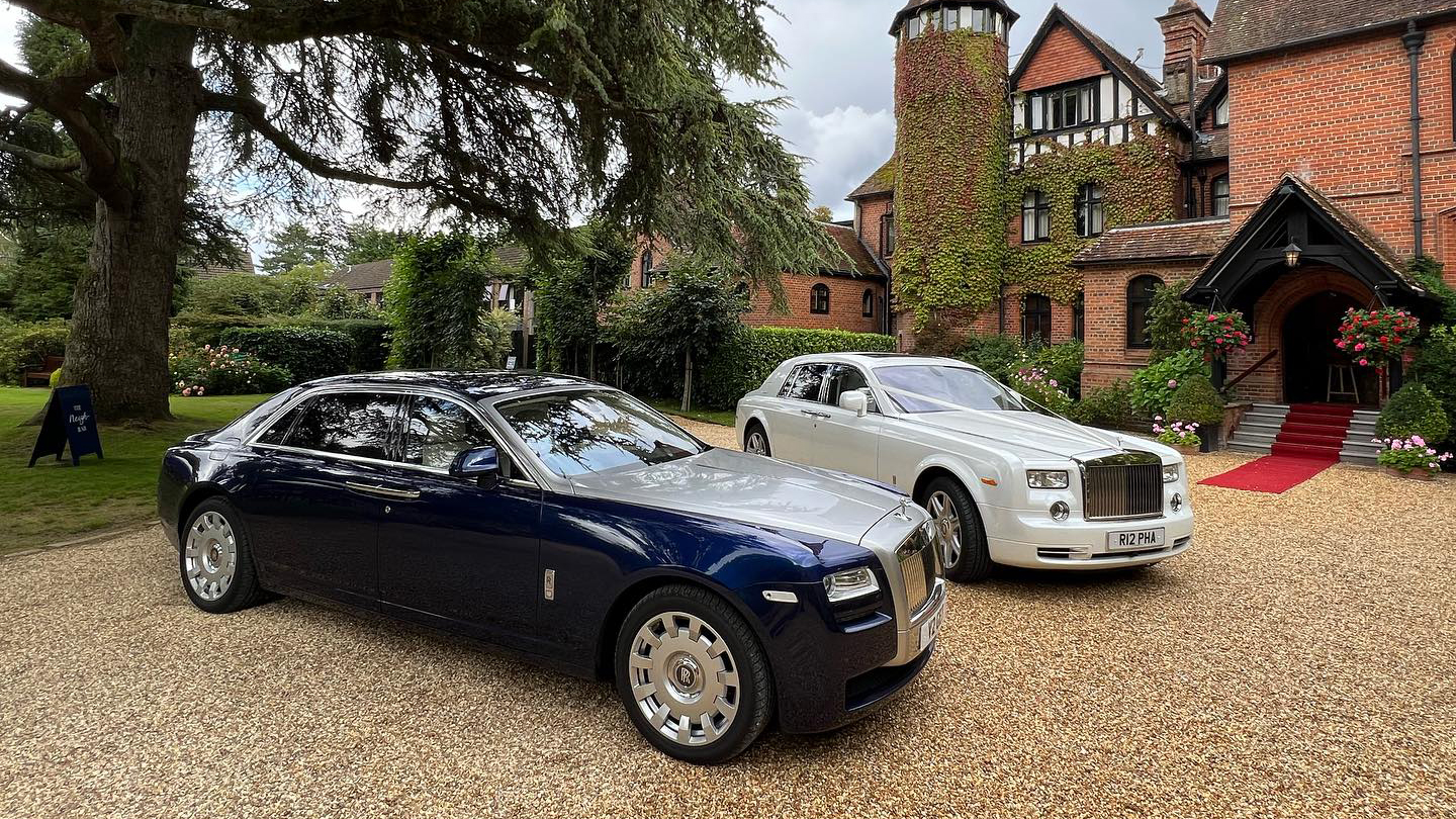 Two Modern Rolls-Royce at a Hampshire Wedding. White Rolls-Royce Phantom is decorated. The second vehicle is a Silver and Blue Rolls-Royce Ghost.