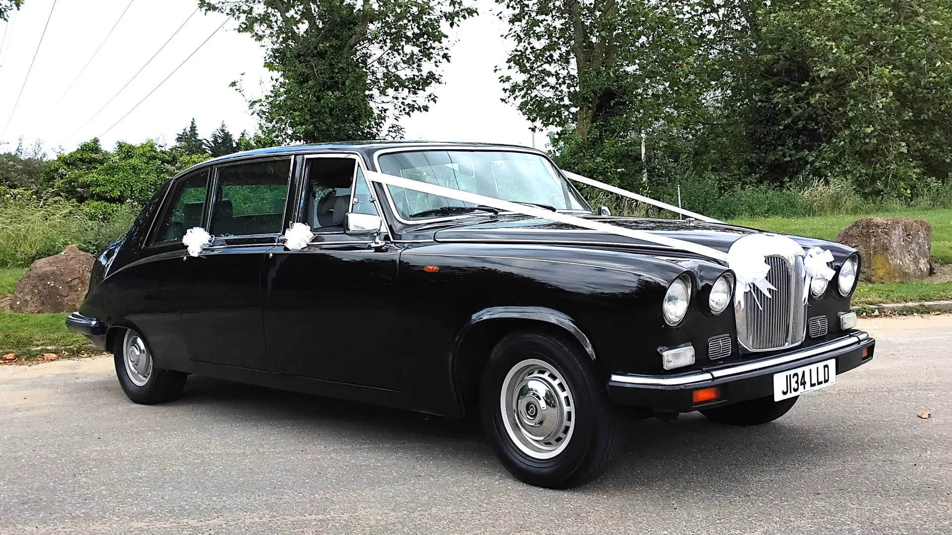 Right side view of Black Daimler Limousine with wedding ribbons