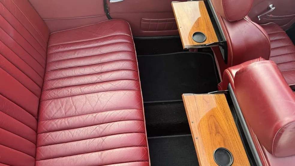 Maroon Leather seats inside a Beauford with wooden picnic table