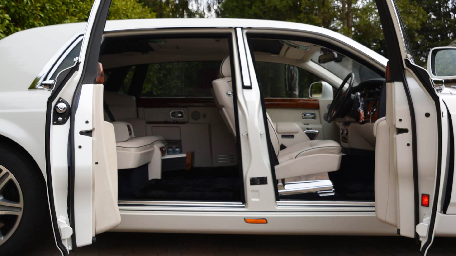 sode view of white phantom with doors open showing cream leather interior.