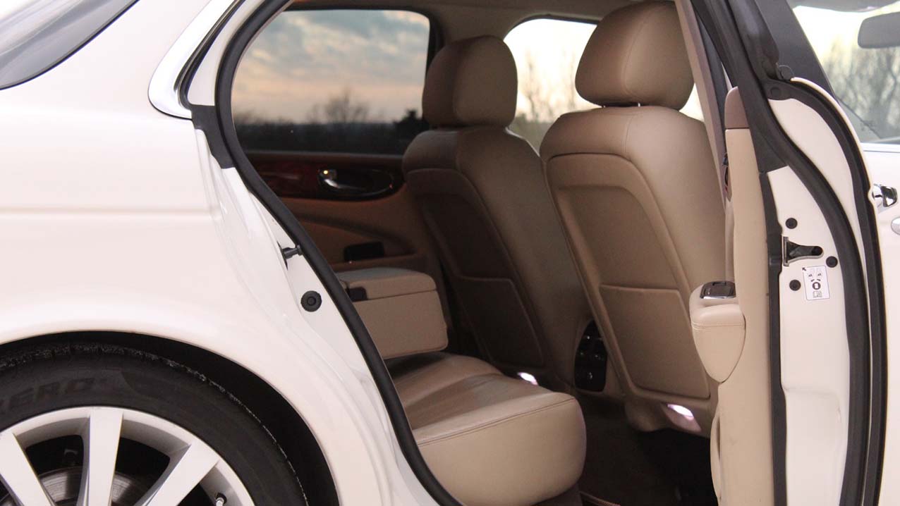 Rear interior view of White Jaguar XJ showing cream leather interior