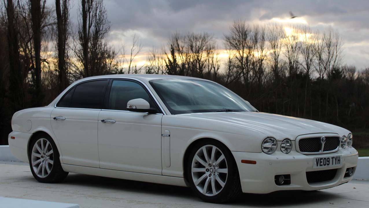 White Jaguar XJ front right view showing the twin headlights and large alloy wheels