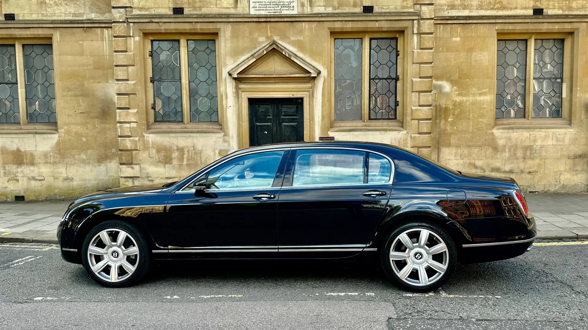 Left side view of Black Bentley parked in the street of Northampton