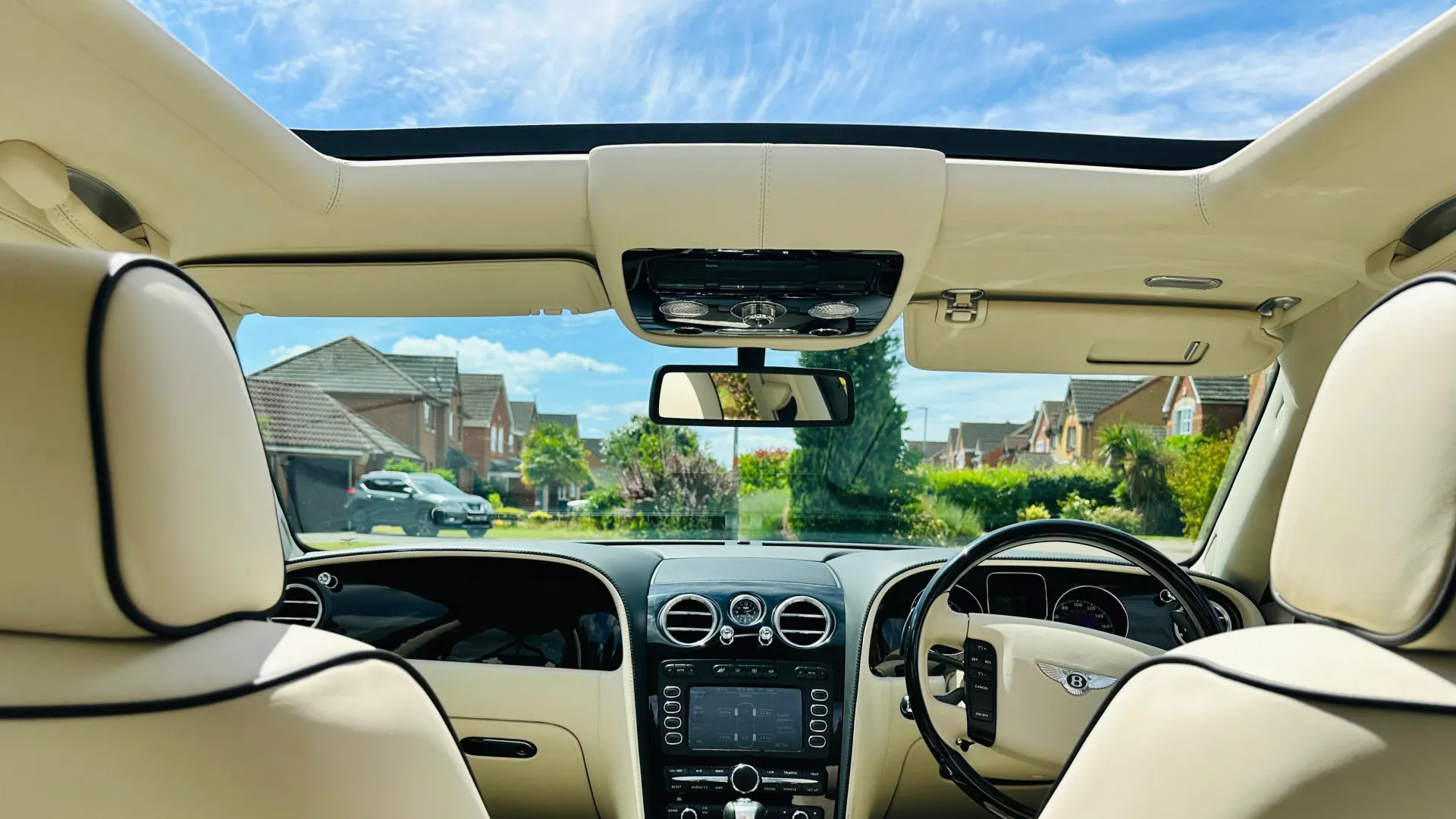 interior photo showing cream leather interior inside a Bentley Flying Spur with sunroof open