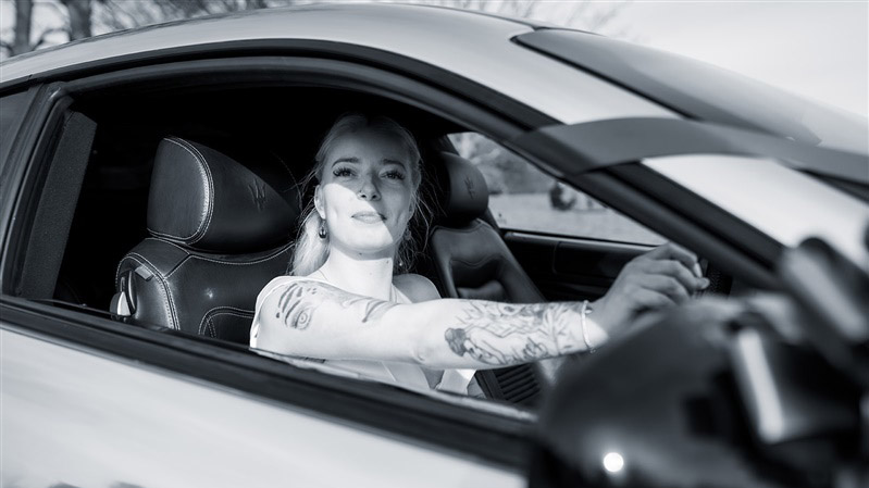 Black * White photo of a bride seating ion the driver's seat of a Maserati