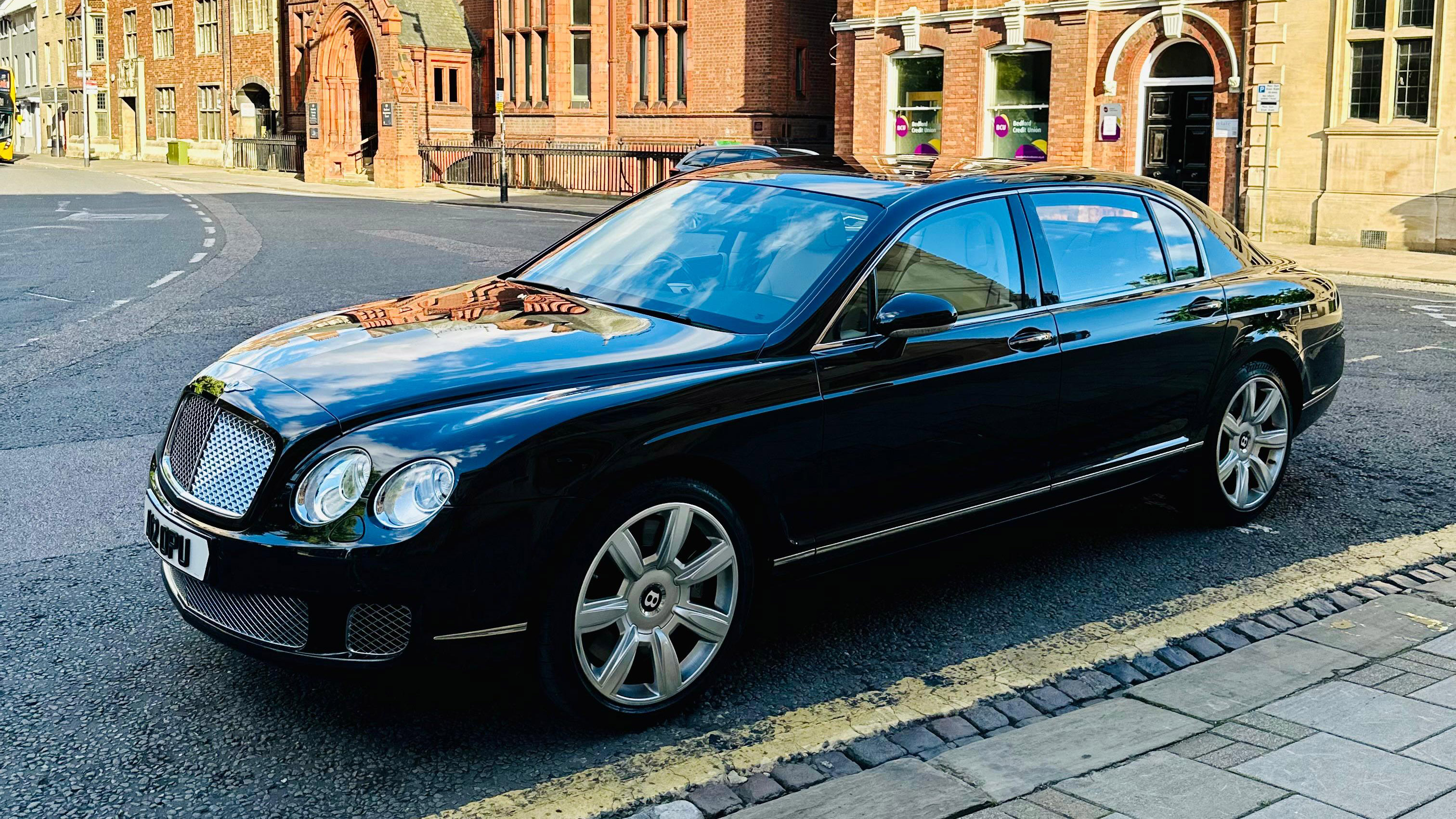 Left side view of black Bentley Flying Spur parked on the side of the road