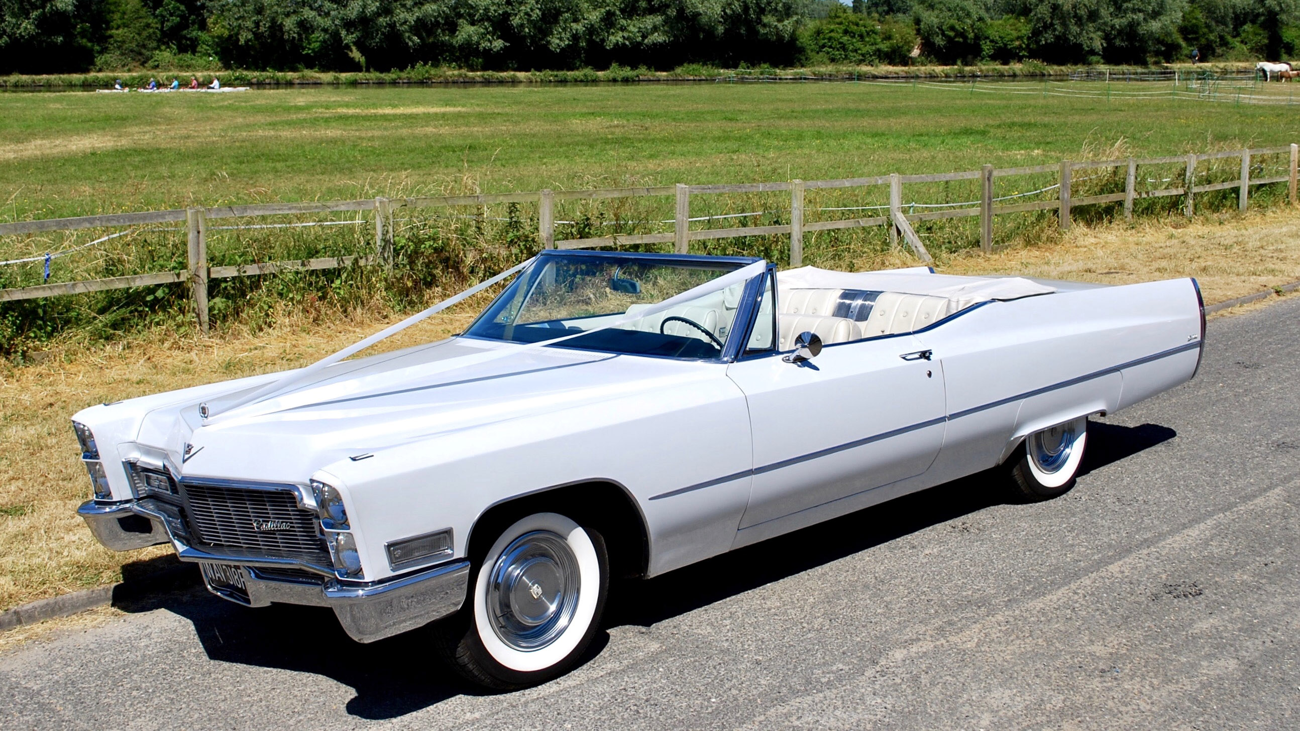 Classic American Cadillac in White with white leather interior and Convertible roof down parked on the side of the road in rural Cambridgeshire