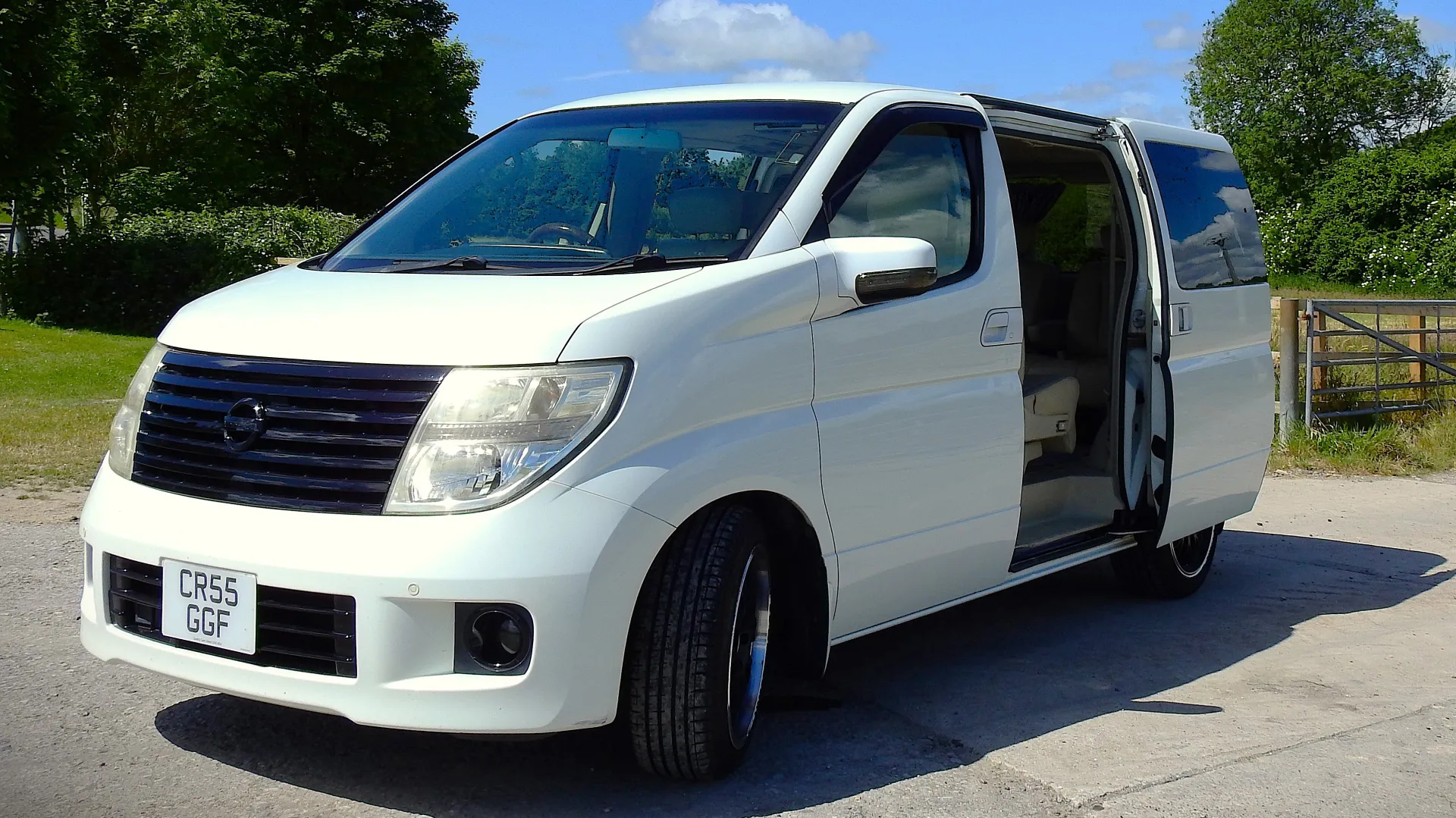 Front side view of White Nissan Elgrand with side rear door oppen