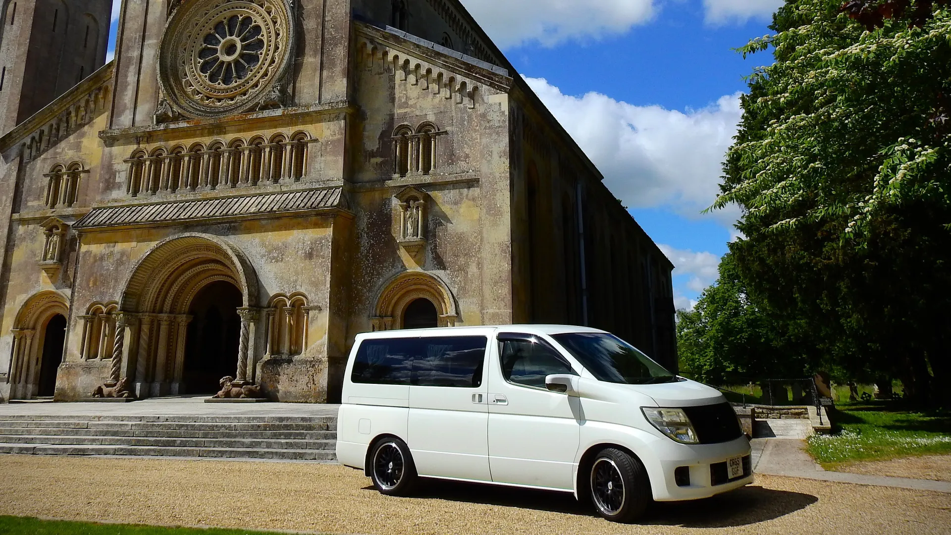 Right side view of a White Nissan Elgrand in front of a Church in Warminster