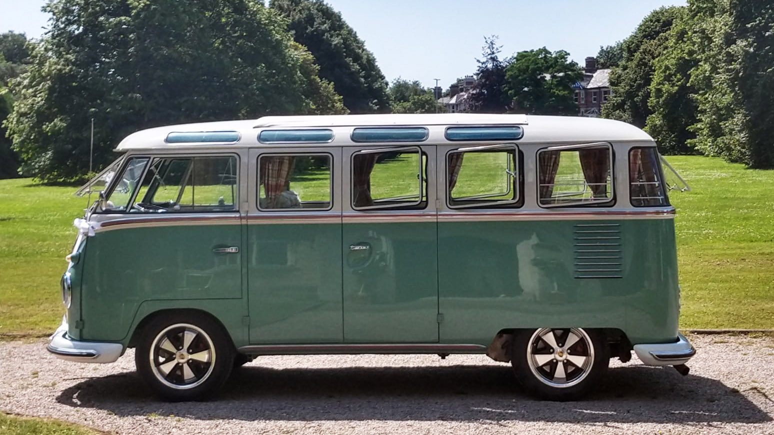 Left side view of two tone White and pale green campervan with chrome wheels