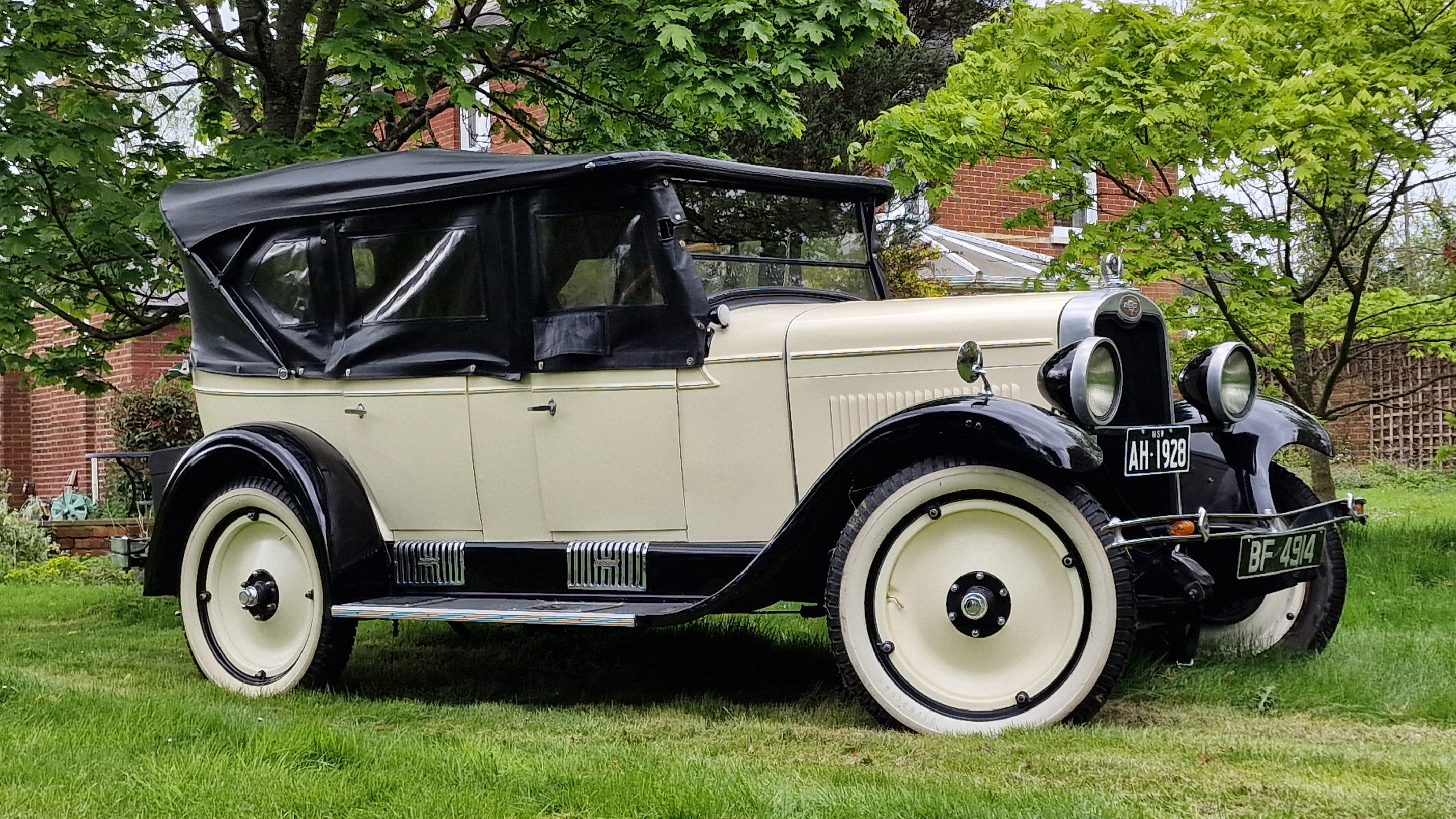 Right Side view of Ivory and Black Chevrolet with soft top roof closed and side windows