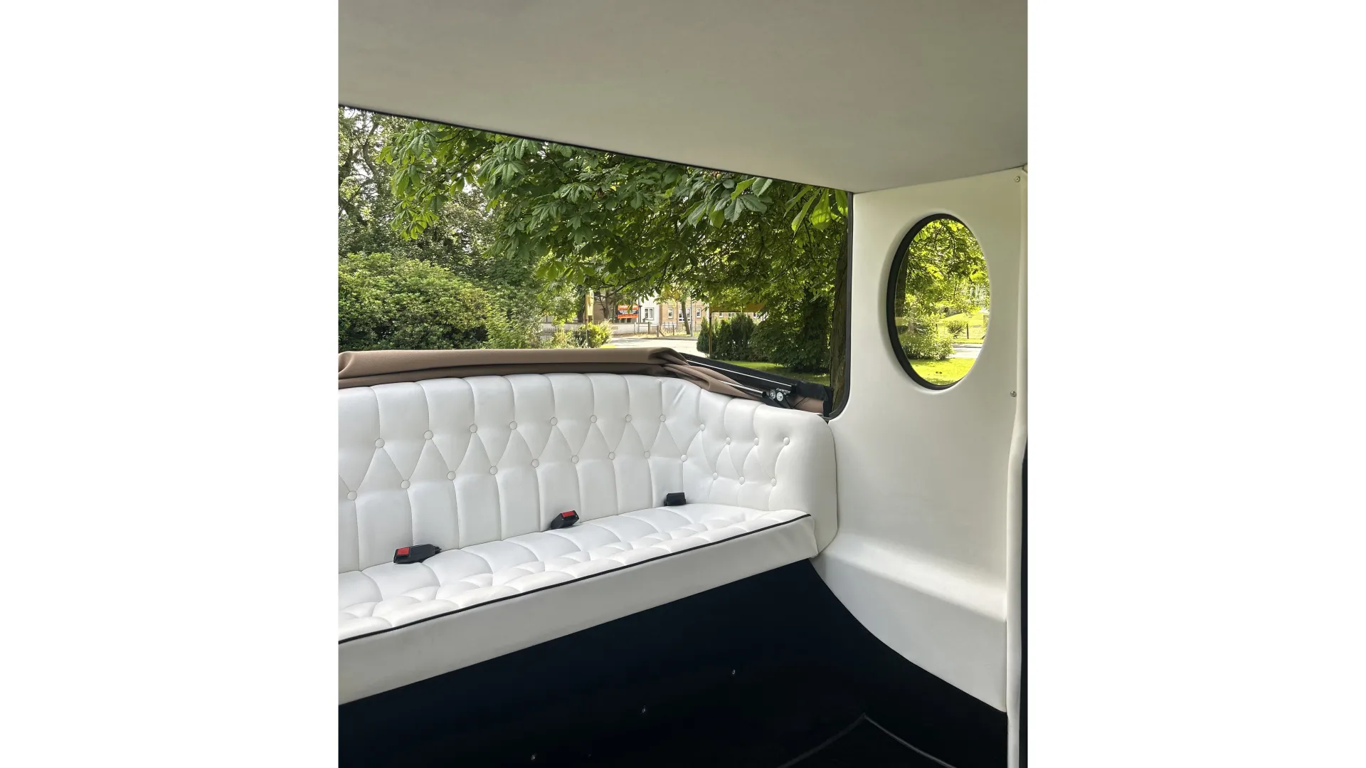 interior of Imperial wedding car white leather seats and roof down