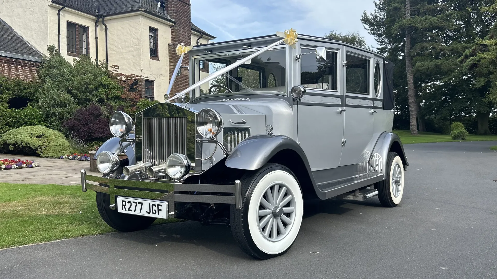 Front left view of Silver and Grey vintage Imperial car with white wpokes wheels and white wall tires.