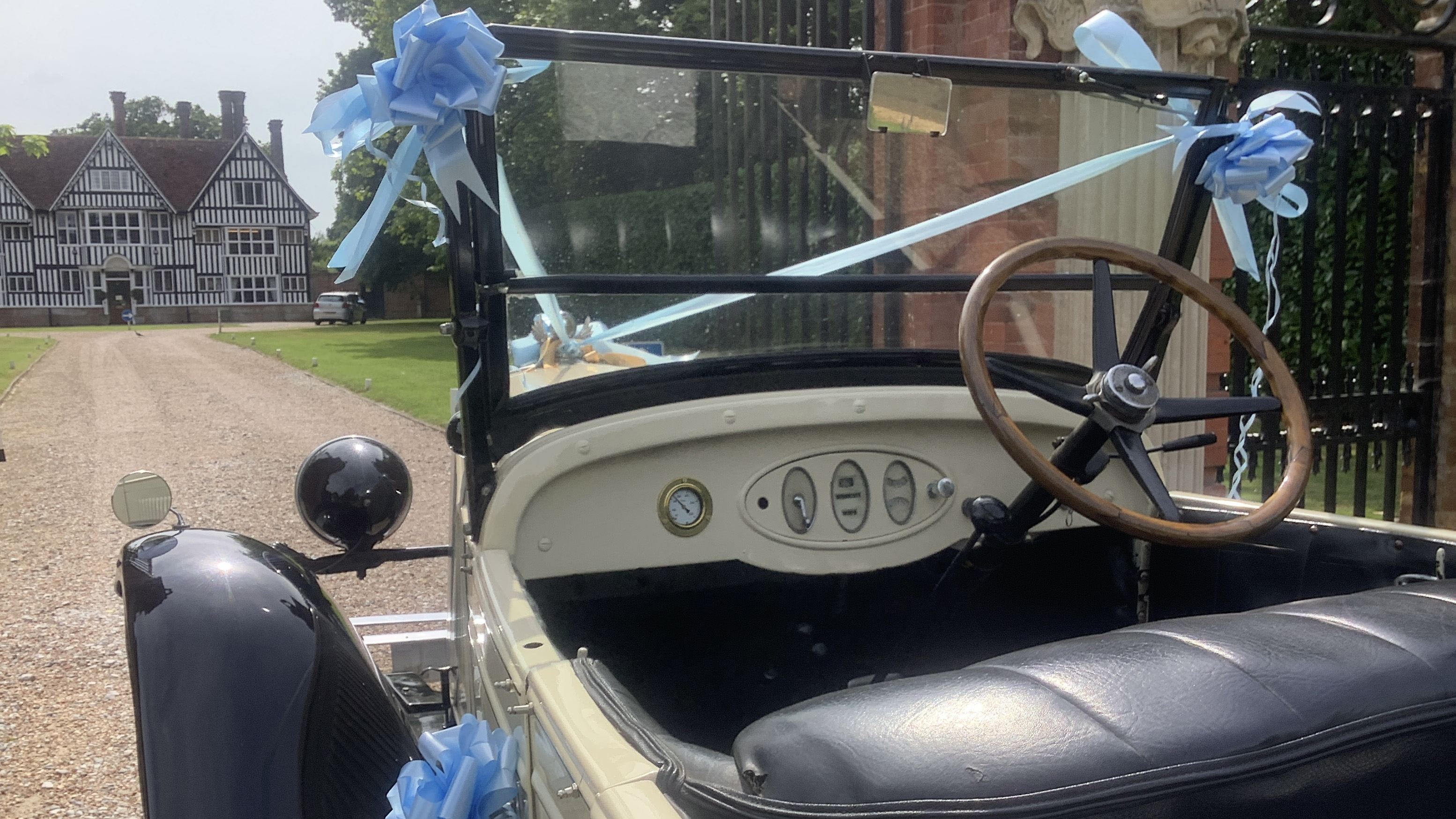 front passenger interior view of vintage chevrolet, light blue bows, ivory dashboard and wooden steering wheel