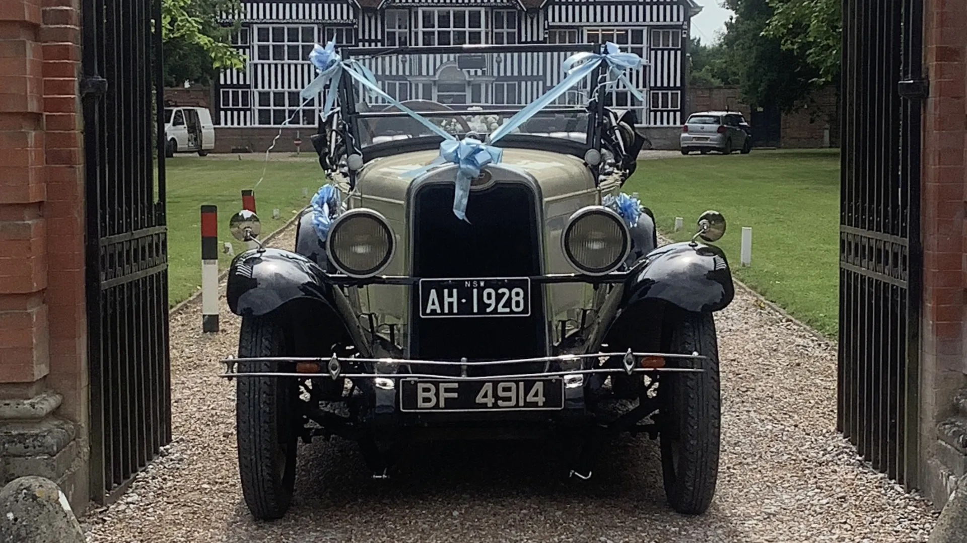 Full front view of convertible chevrolet outside wedding venue's gates