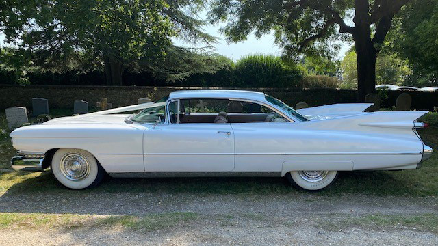 Left view of Whtie American Cadillac decorated with white ribbons and large white wall tires