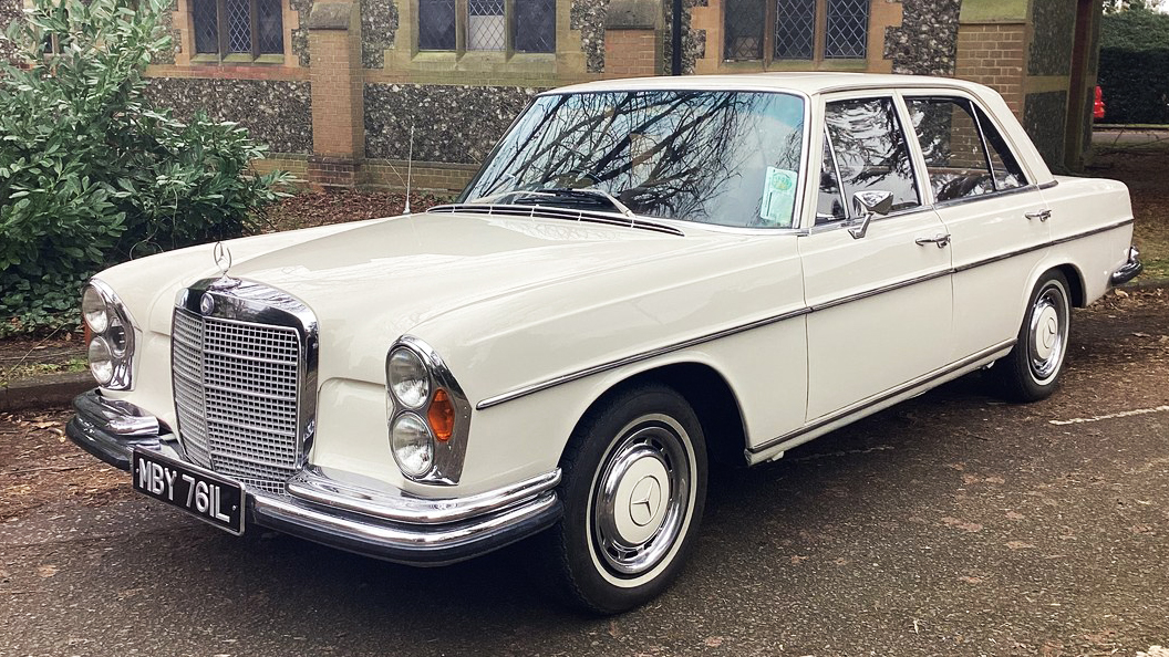 Front side view of Classic Mercedes in Old English white with think white wall tires