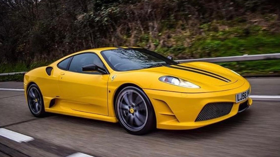 Yellow Ferrari right side view being driven on the road