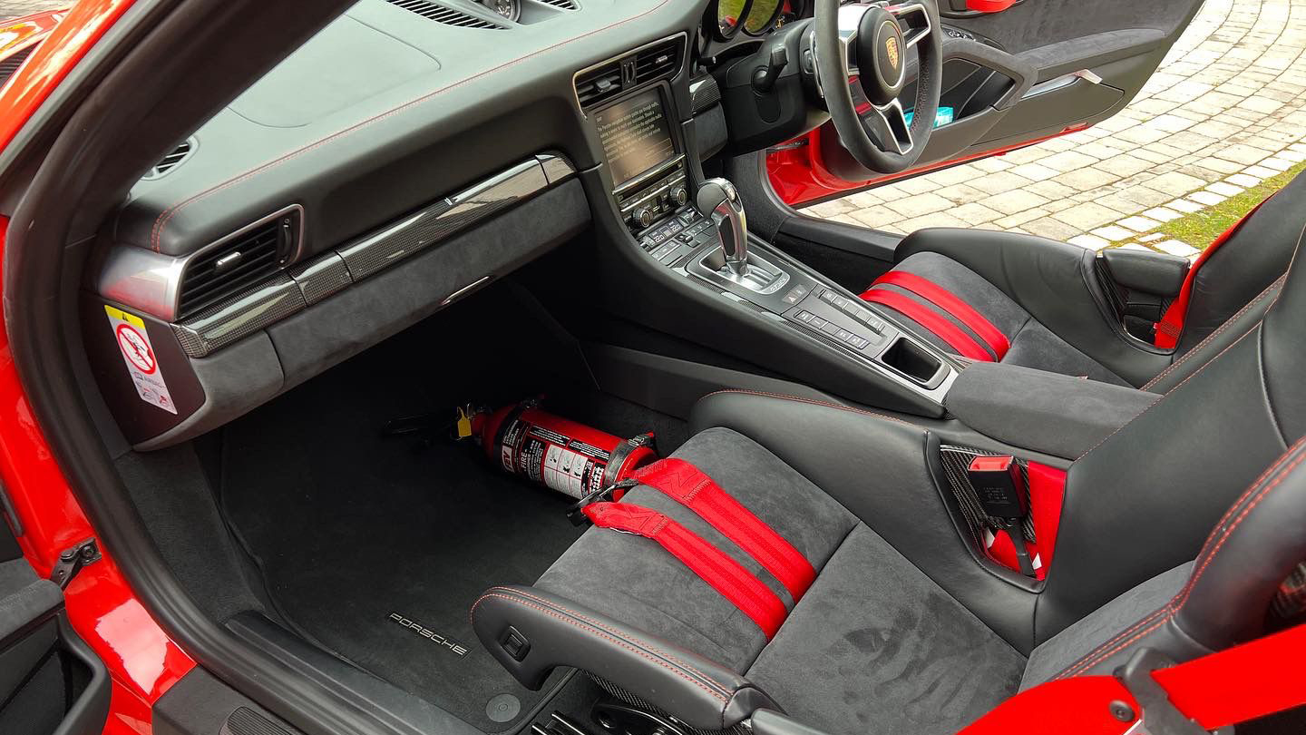 front passenger view of interior grey seat with red sport seat belts harness