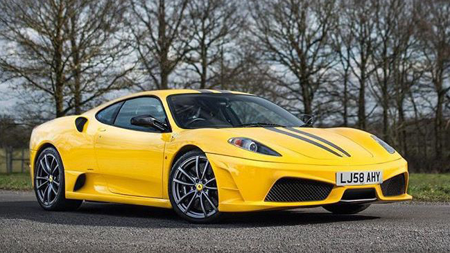 Right front view of Yellow Ferrari 430 Scuderia with large alloy wheelsand 2 thin black strip on bonnet