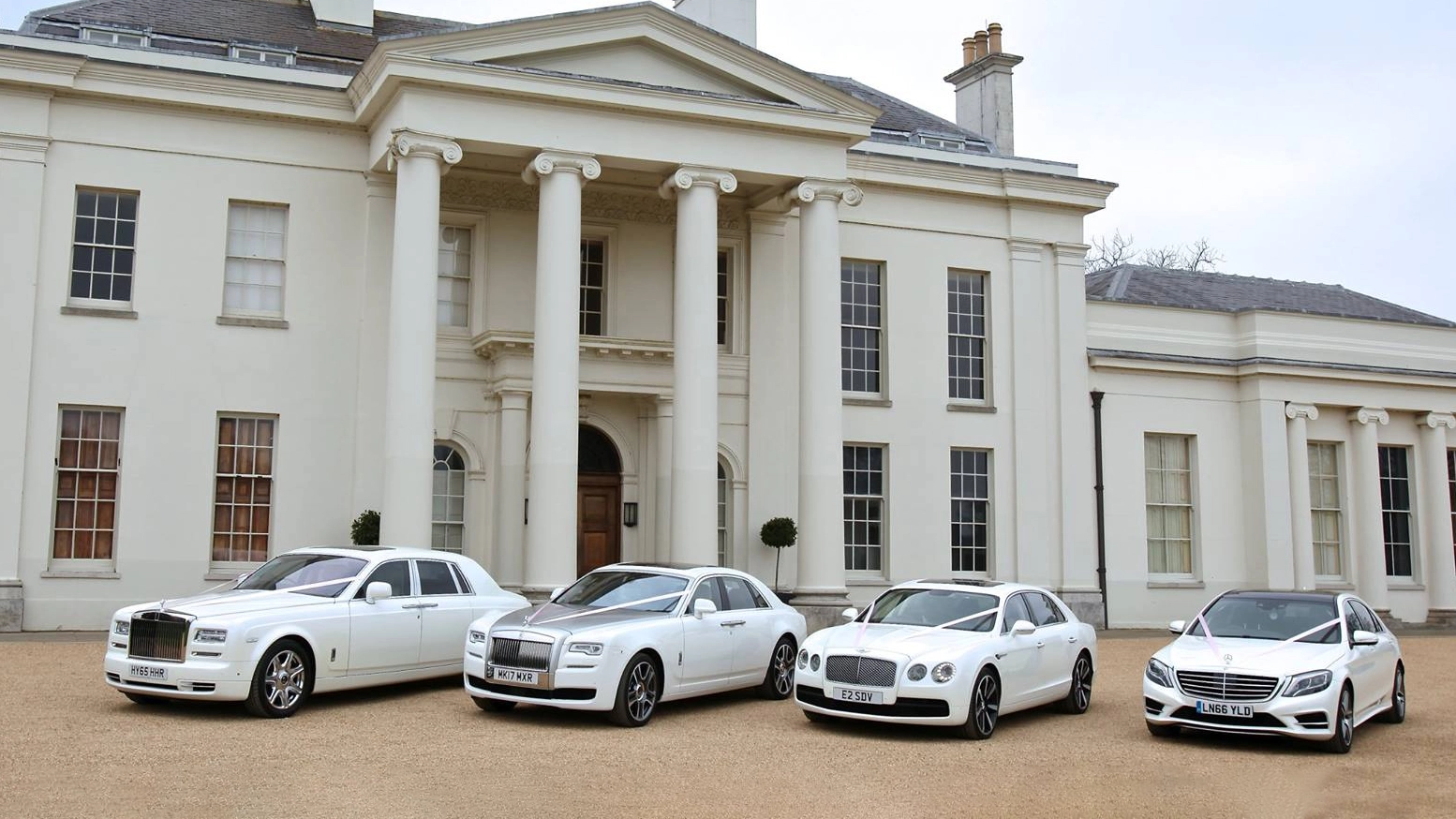 A selection of four modern White cars decorated with matching white ribbons. From left to right: Rolls-Royce Phantom, Rolls-Royce Ghost, Bentley Mulsanne and a White Mercedes.