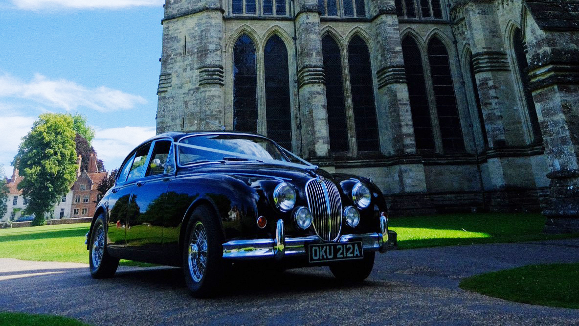 Black Jaguar Mk2 decorated with ribbons in front of Cathedral